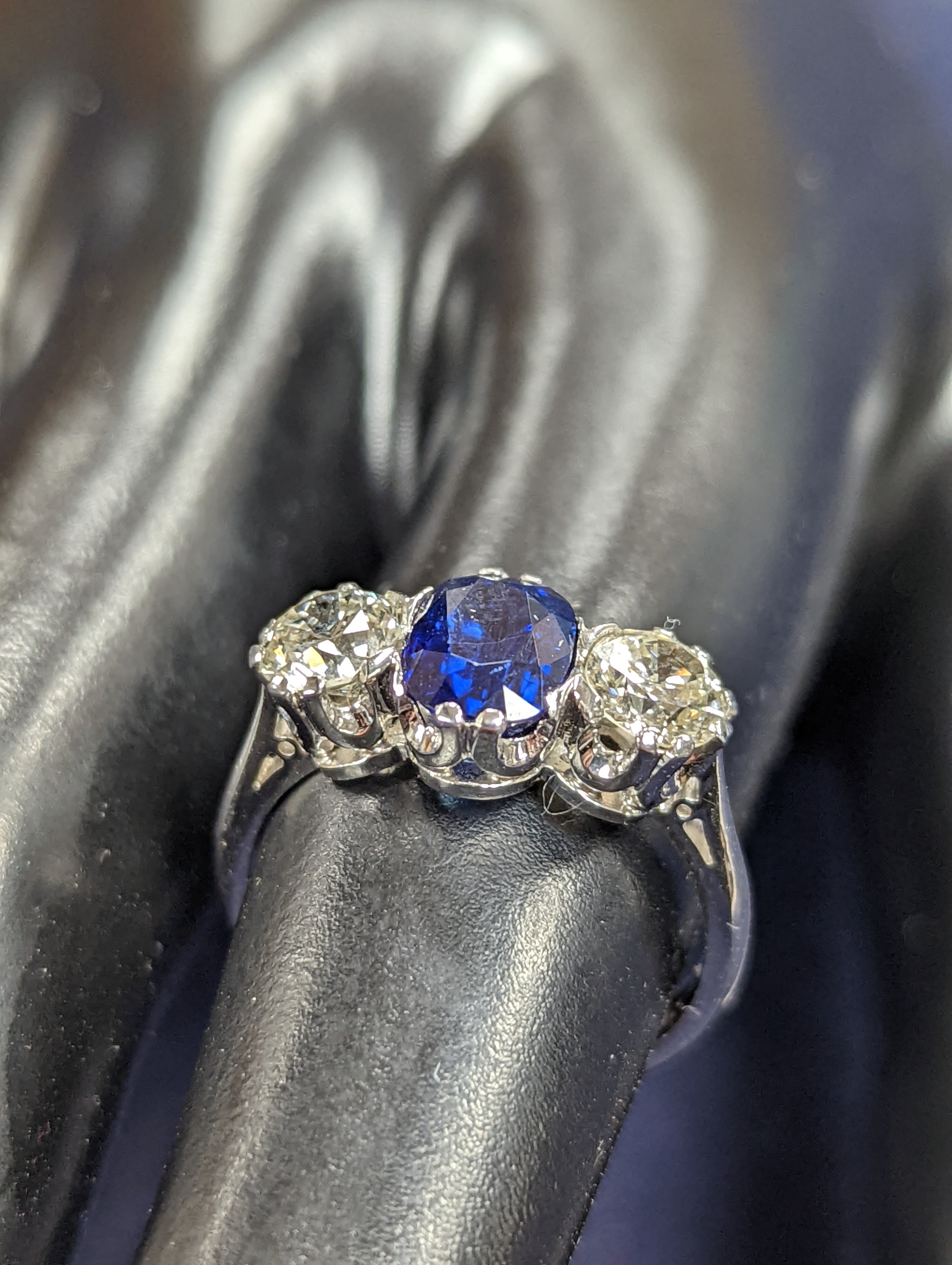 A modern 18ct white gold, single stone sapphire and two stone diamond set ring, size L, gross weight 4.2 grams